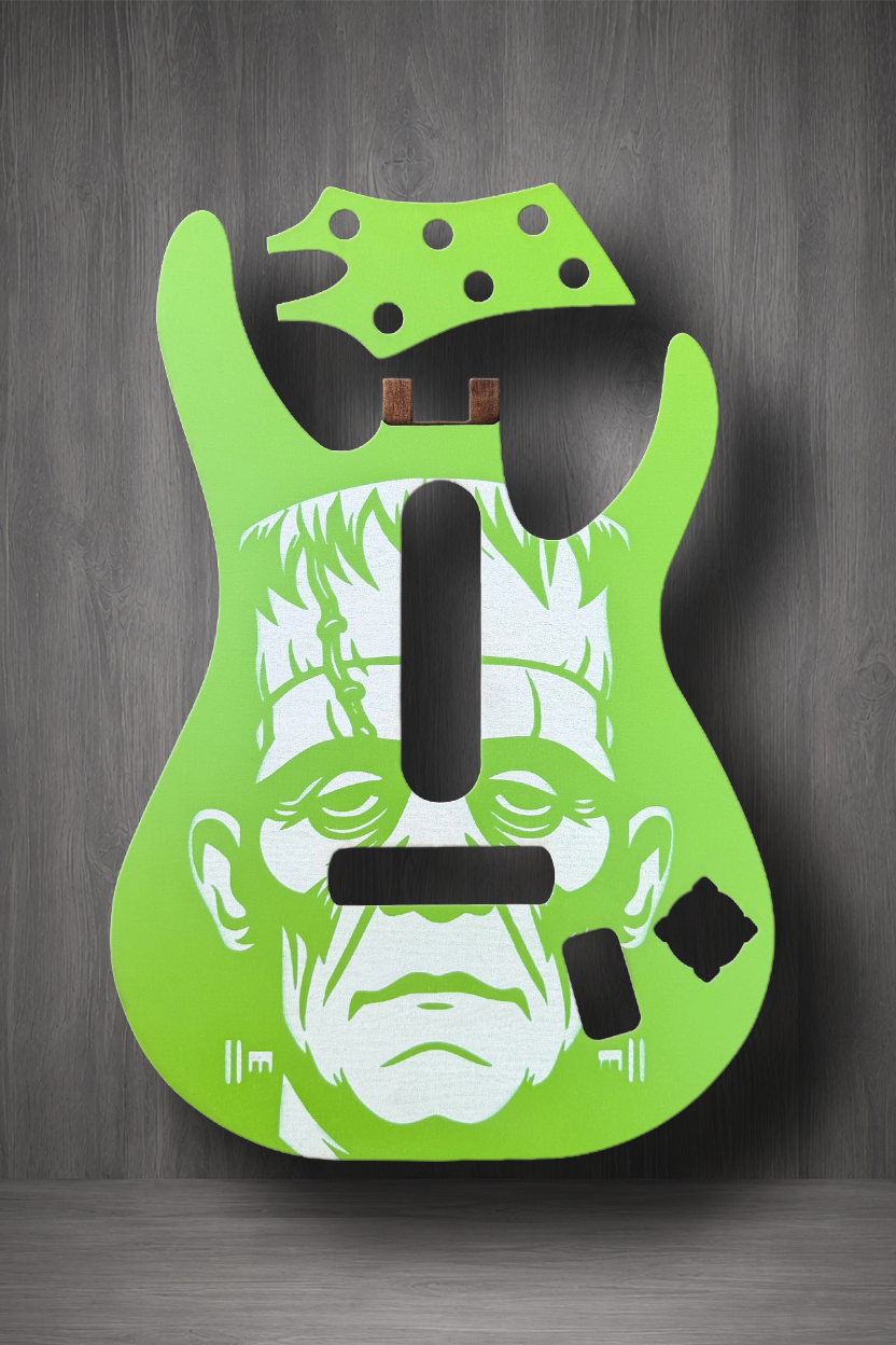 A bright lime green MagnaPlate today and Headstock set, featuring a white illustrated face reminiscent of Frankenstein's monster