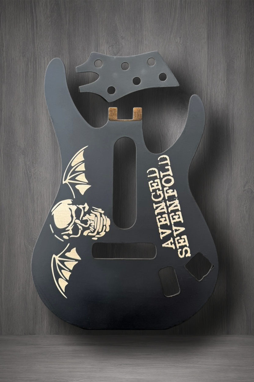 A matte black MagnaPlate body and matching headstock. The body features a laser engraved graphic of a skull and bat with the text 'AVENGED SEVENFOLD' printed vertically.