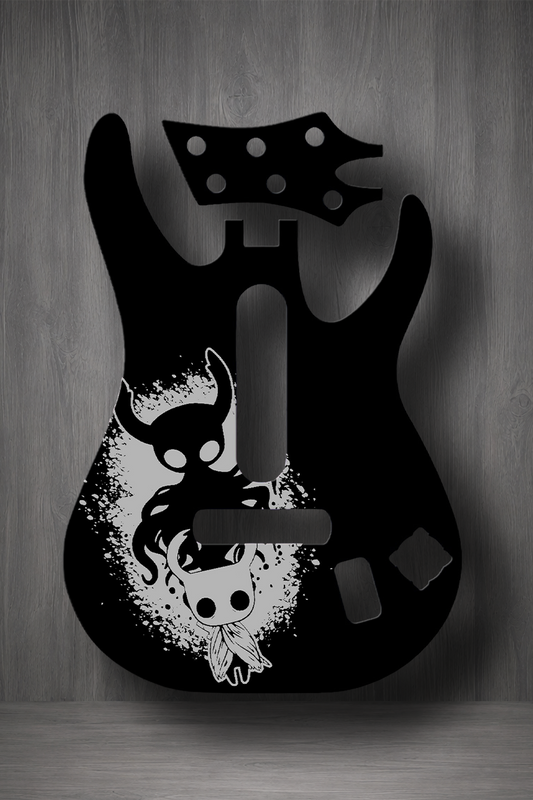 A black electric guitar body silhouette with a stylized white skull and horned figure graphic, shown against a gray wood-textured background.